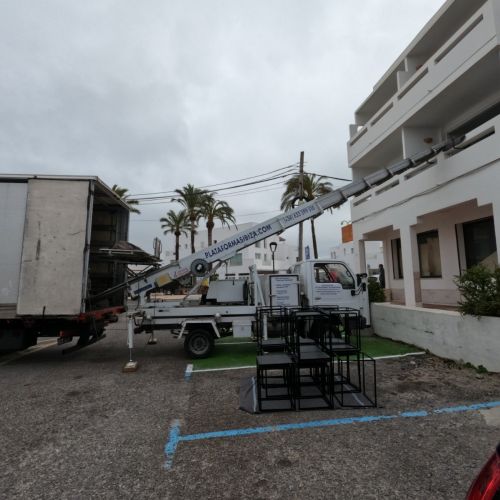 Vista lateral del camión de alquiler con la plataforma de elevación de materiales